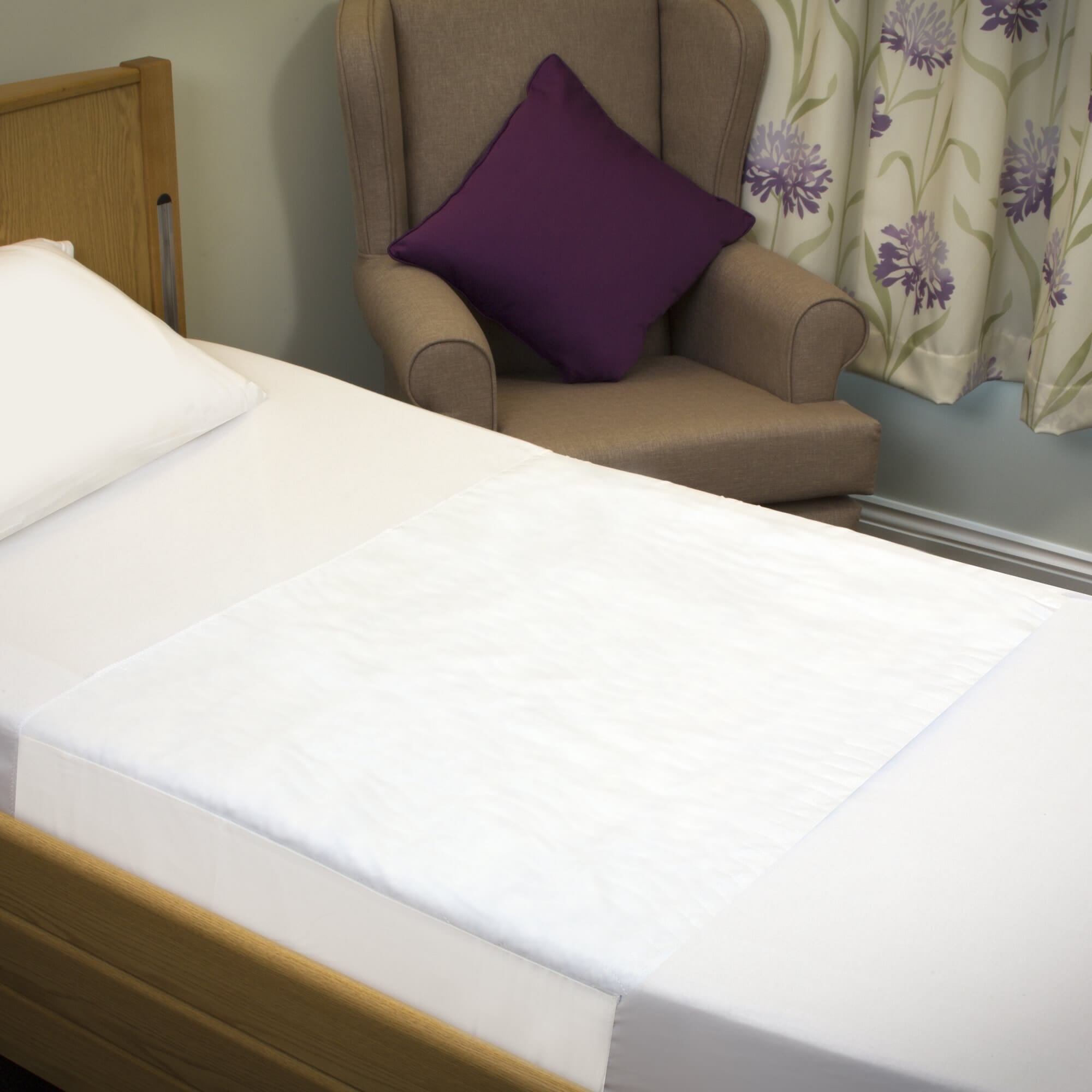 economy bed pad with tucks shown on a bed