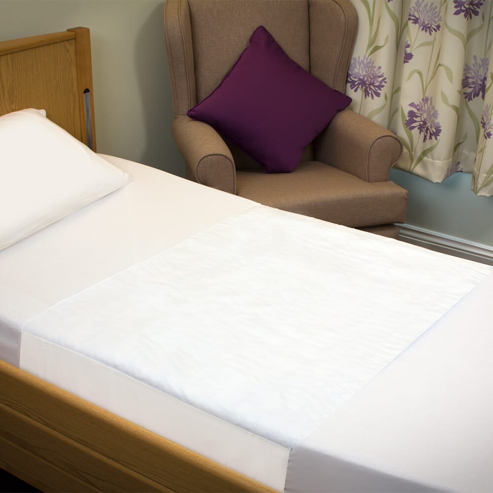 economy washable bed pad with tucks on bed